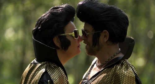 Filmstill aus dem LSF-Trailer 2018: zwei Personen in Elvis-Kostüm sehen sich an, die Gesichter dicht beinander