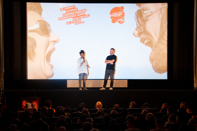 Schulvorstellung 2018: im Kinosaal, vor Leinwand zwei Menschen miteinander redend